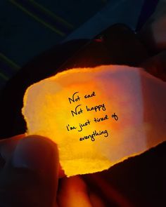 a person holding a piece of paper with writing on it in their left hand and the light shining through them