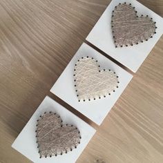 three cards with hearts on them sitting on a table