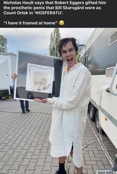 a man in white robe holding up a framed photo with words on it and an image of a dog