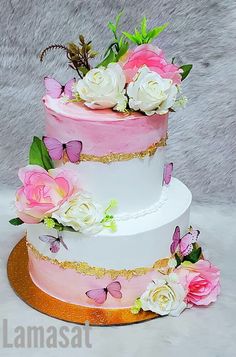 a three tiered cake with pink and white flowers