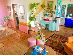 a living room filled with lots of furniture and colorful decor on the walls in front of it