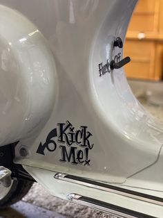 a white scooter with the words kick me on it's front tire