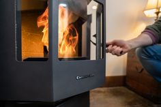 a man kneeling down in front of an oven with fire coming out of the door