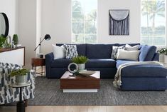 a living room with blue couches and pillows on top of the sofa is shown