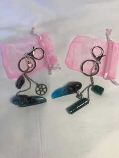 two pairs of scissors and some other items on a white tablecloth with pink organ bags