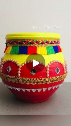 a red and yellow decorated bowl sitting on top of a table