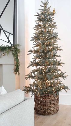 a christmas tree in a basket next to a fireplace