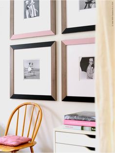 several framed pictures hang on the wall above a desk with a chair and table in front of it