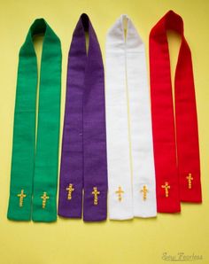 four different colored ties with gold crosses on each one and the other in red, white, green, and purple