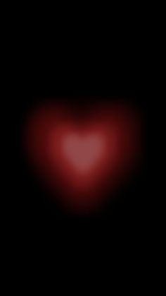 a red heart shaped object in the dark