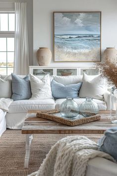 a living room filled with white furniture and lots of pillows on top of the couch