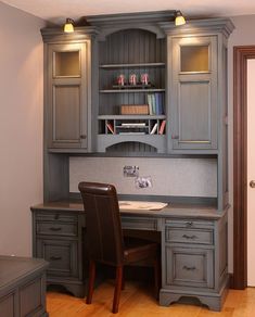 a home office with gray cabinets and wooden floors