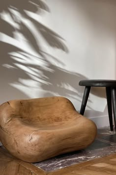 a wooden chair sitting on top of a hard wood floor next to a black table