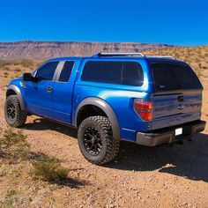 a blue pick up truck parked in the desert