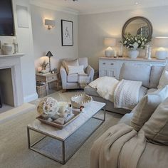 a living room filled with furniture and a flat screen tv mounted on the wall above a fire place