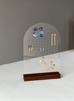 a clear acrylic display with earrings on it