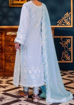 Introducing our New collection 'FASANA-E-ISHQ EID LUXURY LAWN COLLECTION' by Asim Jofa designed to make you look and feel your best. Embrace the glimmers of frost with this captivating ice blue attire adorned with intricate white and self-colored threadwork and shimmering silver 3mm sequins. Like stars in a winter sky, the neckline and borders shimmer with luxurious 9mm sequins casting a spell of enchantment. With embroidered details on the neckline, borders and sleeves, this ensemble captures the essence of frosty elegance. The embroidered border for the hemline and chaak adds a touch of winter magic while the embroidered dupatta with four-side border drapes you in the glimmers of frost. Embroidered Neckline For Front. Embroidered Front With Thin Border On Lawn. Embroidered Neckline For B Elegant Light Blue Dress With Dupatta, Festive Light Blue Dress For Eid, Light Blue Georgette Dress For Eid, Elegant Light Blue Dresses With Dabka Work, Festive Light Blue Dresses With Mirror Work, Fitted Light Blue Dress For Eid, Light Blue Fitted Dress With Mirror Work, Velvet Anarkali, Organza Kurti