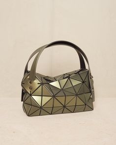 Boston bag by Bao Bao Issey Miyake in khaki green. Classic hand or shoulder bag with twin adjustable straps. Handy size with sturdy base and studded feet. Compact rectanguar shape offers a deceivingly spacious capacity, while the signature triangular motif has a reflective leather-like finish. H 16.5cm x W 33cm.Polyvinyl Chloride, Polyster, Nylon.Made in Japan. Bao Bao Issey Miyake, Bao Bao, Polyvinyl Chloride, Boston Bag, Issey Miyake, Khaki Green, Green Bag, Made In Japan, Boston