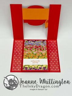 a card in a red box with flowers and polka dots on the bottom, inside it