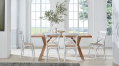 a dining table with four chairs and a potted plant in the middle of it