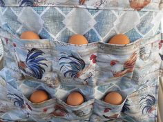 three eggs in an egg holder with roosters on the fabric and blue checkered background