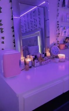 the vanity is lit up with candles and other items on it, including an alarm clock