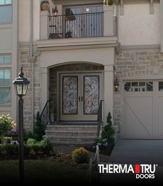 the front entrance to a house with two doors and a light pole in front of it