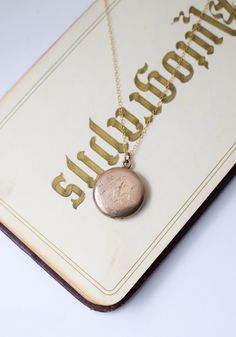 c. 1890s tidy, smaller sized round locket in warm 1/4 gold (higher gold content than gold-fill) with decorative cursive "H" on one side and initials "A.F.M." on the other. interior compartments contain original removable frame pieces for storing photos or other tiny keepsakes (a lock of hair, a mantra, etc). paired with an 18" modern 14kt goldfill chain hallmarked for Carter, Qvarnstrom & Remington Company. and "Joint Gold, 1/4 Gold" 7/8" dia. excellent condition. --------- boxes and photo props shown not included. jewelry is shipped in padded presentation boxes. --------- antique and vintage lockets are sourced from a variety of decades. Most are 1890-1950 and were made in Rhode Island or Massachusetts (where much of the costume jewelry from the early-mid 20th century in the US was made!) Vintage 14k Gold Locket Necklace Stamped 14k, Vintage 14k Gold Locket Necklace, Victorian Round Locket Necklace Stamped 14k, Engraved 14k Rose Gold Locket Necklace, Engraved Rose Gold Heirloom Locket Necklace, Antique Gold Jewelry With Initials, Heirloom Medallion Locket Necklace In Rose Gold, Victorian 14k Stamped Round Locket Necklace, Victorian Engraved Rose Gold Locket Necklace