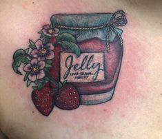 a woman's chest with a jar of jelly and strawberries on it