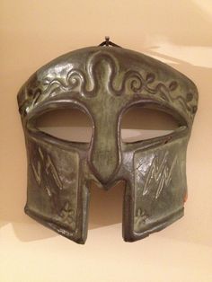 a green mask hanging on the wall