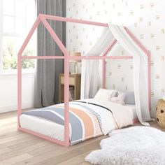 a pink and white bed in a room with a rug on the floor next to it