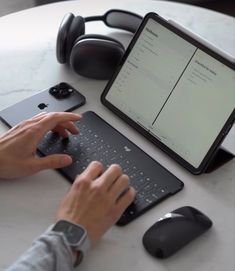 a person typing on a laptop with headphones