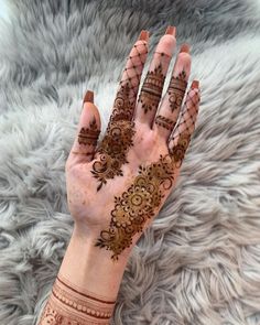 a woman's hand with henna tattoos on it