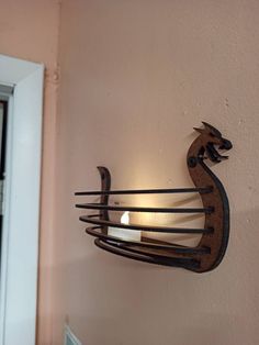 a candle is lit on the wall next to a light fixture that looks like a deer