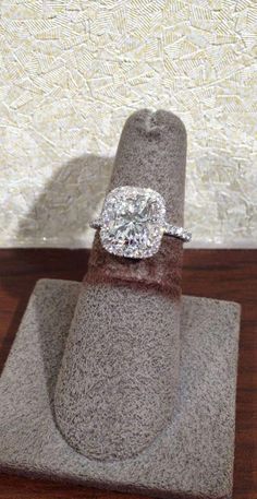 an engagement ring on top of a piece of cloth with a diamond in the middle