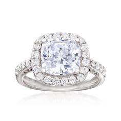 an engagement ring with a cushion - cut diamond surrounded by round brilliant pave diamonds