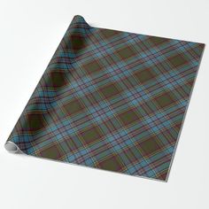 a green and blue plaid wrapping paper on a white surface with the image of a tartan