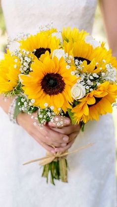 a bride holding a bouquet of sunflowers