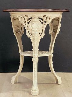 an ornate white table with wood top