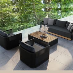 an outdoor living room with black couches and coffee table