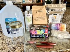 the contents of a crafting kit sitting on top of a counter next to a bottle of water