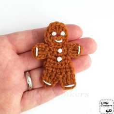 a crocheted ginger brooch is shown in the palm of someone's hand