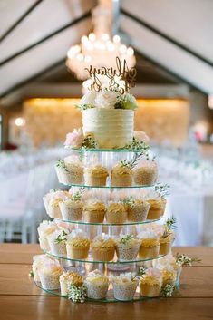 a wedding cake and cupcakes are stacked on top of each other