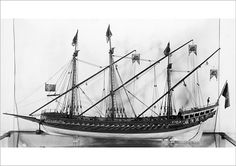 a black and white photo of a ship in a glass case with flags on it