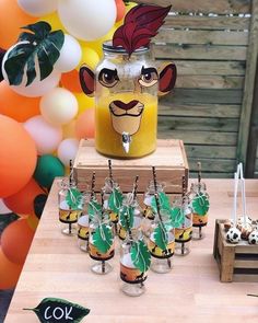 an animal themed birthday party with balloons and decorations on the table, including jars filled with drinks