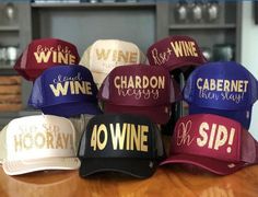 six hats with wine written on them sitting on a wooden table in front of a window