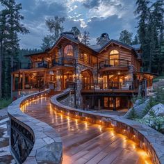 a large wooden house with lights on it's side and stairs leading up to the front door