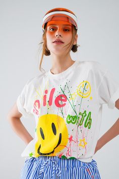 Introducing the Graphic "Smile With Me" Text T-Shirt in White, a statement piece that blends Italian craftsmanship with casual comfort. Crafted from 100% cotton, this t-shirt ensures a soft and breathable feel, ideal for everyday wear.  Designed with an abstract print and featuring a crew neckline and short sleeves, this shirt offers a relaxed fit that runs true to size. The front showcases a playful "Smile With Me" text, adding a touch of charm and positivity to your outfit.  The model, standing at 5'10" with measurements of 31-24-35, effortlessly showcases the t-shirt in size U. Known for its casual appeal, this piece is perfect for pairing with your favorite jeans or shorts for a laid-back look.  Embrace comfort and style with the Graphic "Smile With Me" Text T-Shirt in White, a versati Playful White T-shirt With Smiley Face, Playful Cotton T-shirt For Streetwear, Playful White T-shirt For Everyday, Fun Cotton T-shirt With Smiley Face, Playful T-shirt For Summer Streetwear, Playful White Top With Smiley Face, White Playful T-shirt With Smiley Face, Playful Relaxed Fit T-shirt With Text Print, White Smiley Face T-shirt