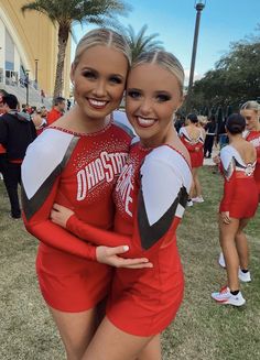 two cheerleaders hugging each other on the field