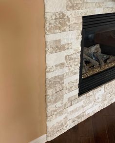 a white brick fireplace in a living room with wood flooring and walls painted tan